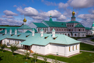 architectural ensemble with the white-stone religious architecture of the New Jerusalem on a sunny bright day and a dramatic blue sky with clouds in Istra Russia