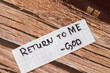 Return to God Jesus Christ. A handwritten quote on wooden background with a Holy Bible Book. The inspiring message of hope and trust. Christian biblical concept of faith and repentance. A closeup.