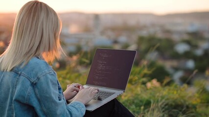 View through a young woman, freelance data source, working in nature with city and sunset views, coding big data programming, artificial intelligence engineering, IT engineering working on an