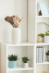 Minimal background image of home decor accessories on white shelf with flower vase, copy space