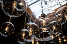 A View Of A Background Of Modern Glass Globe Hanging Light Fixtures, Seen In An Interior Facility.