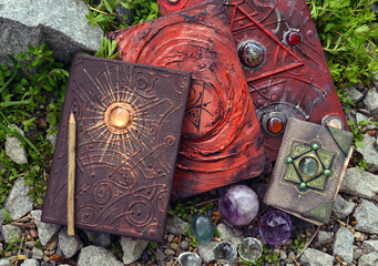 Wall Mural - Three magic book of spells and witch diary witch crystals in the garden.