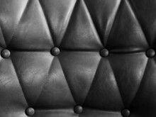 Grey Leather Sofa With Pins And Buttons Texture Background. Close Up Of Vintage Black Leather Sofa Surface.