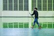 Construction workers are using rollor spreading green epoxy coating floor for Self-leveling method of epoxy floor finishing work