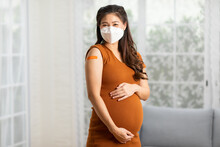 Pregnant Asian Woman wear face mask received anti virus vaccine cheerful with bandage,Pregnancy of young woman enjoying with safety life after got COVID-19 vaccination,vaccination in Pregnant Concept