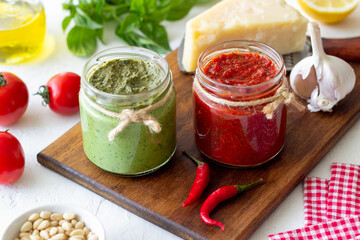 Two glass jars with red pesto and basil pesto. National kitchen. Healthy eating. Vegetarian food.