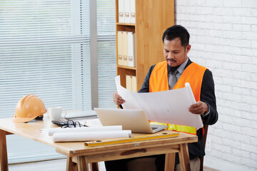 Head contractor working with documents, he is rolling out construction plan