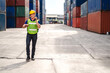 © Art_Photo - Professional engineer container cargo foreman in helmets working standing and using walkie talkie checking stock into container for loading.logistic transport and business industry export