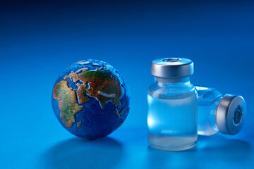 vaccine bottle and globe on blue background