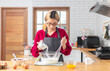 © peerasin - Asian chef woman blend dough and chocolate with beater for cooking chocolate cake with happy feeling in the morning