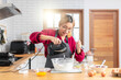 © peerasin - Asian girl using the blender, blend dough and other ingredients for cooking the chocolate cake with happy feeling in the kitchen room.