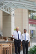 © DragonImages - Middle-aged business colleagues walking back to office after having lunch in outdoor cafe