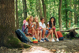 Fototapeta  - Sitting in the camp. Kids strolling in the forest with travel equipment