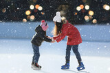 Mother and daughter spending time together at outdoor ice skating rink