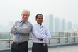 © DragonImages - Happy confident real estate investors standing on bridge in front of new city district