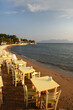tables set for dinner on the beach at sunset over the sea in Aegina in Greece