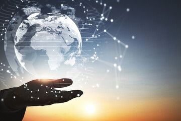Poster - Close up of backlit hand holding abstract glowing polygonal globe on blurry sunset background with mock up place. Network, communication and global innoovation concept.