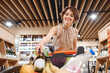 © ViDi Studio - Young happy smiling fun satisfied woman in casual clothes shopping at supermaket store hold white wine alcohol put bottle in grocery cart inside hypermarket Purchasing gastronomy lifestyle concept.