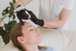 © Natalya - permanent make-up master corrects eyebrows young woman