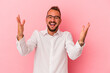 © Asier - Young caucasian man with tattoos isolated on pink background  celebrating a victory or success, he is surprised and shocked.