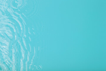 Wall Mural - Water tranquil ripple background. Water texture, circles and bubbles on a liquid blue surface. Cosmetic products and flat design concept