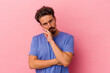 Young caucasian man isolated on pink background tired of a repetitive task.