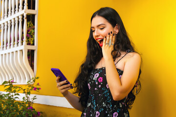 Woman talking on her cell phone on a yellow wall