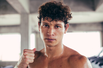 Portrait of boxer standing guard position ready to fight. Muscular topless man do exercise workout and boxing in gym fitness strength power. sweating and looking at camera