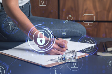 Wall Mural - A businesswoman in casual wear signing the contract to prevent probability of risks in cyber security. Padlock Hologram icons over the working desk.