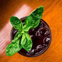 Sticker - cherry lemonade with basil, dark red cocktail at the bar. Fresh homemade cherry lemonade on dark background.