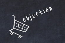 Chalk Drawing Of Shopping Cart And Word Objection On Black Chalboard. Concept Of Globalization And Mass Consuming