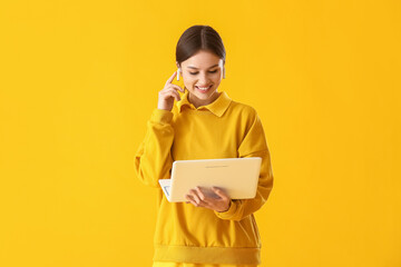 Canvas Print - Young woman with laptop on color background