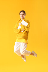 Poster - Jumping young woman with laptop on color background