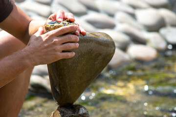 Wall Mural - human hands build a cairn of stones on the water. balance and meditation