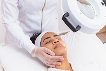 Wall Mural - woman in beauty clinic doing a facial evaluation. Woman doing aesthetic treatment