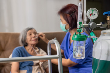 elderly woman wearing oxygen nasal cannula at home.