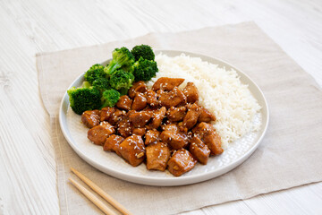 Wall Mural - Homemade Teriyaki Chicken with Rice and Broccoli on a plate on a white wooden table, low angle view.