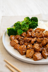 Wall Mural - Homemade Teriyaki Chicken with Rice and Broccoli on a plate on a white wooden background, side view.