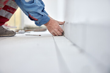 Wall Mural - Ceramics tile man worker placing new tiles on the floor and wall.