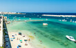 Panoramic view of the seaside and the beach of Otranto seen from the bastion of the castle, with moored boats, bathers and parasols, in Otranto, Salento area, province of Lecce, Puglia, Italy 