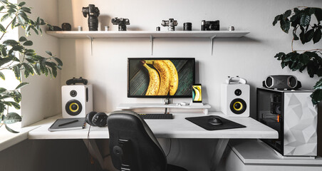 Front view comfortable home office workplace of photographer with computer, camera lens