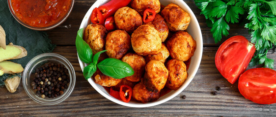 Wall Mural - Chicken meatballs in a plate. Meatballs and basil. Copyspace. Top view. Ingredients. Wooden background