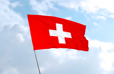 Flag of Switzerland, realistic 3d rendering in front of blue sky