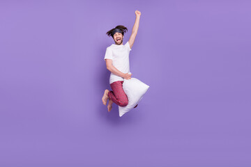 Wall Mural - Full size portrait of carefree overjoyed person flying on cushion raise fist isolated on violet color background