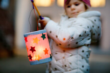 Close-up Of Little Kid Girl Holding Selfmade Lanterns With Candle For St. Martin Procession. Healthy Toddler Child Happy About Children And Family Parade In Kindergarten. German Tradition Martinsumzug