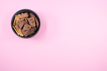 Wall Mural - Vertical shot of bread slices on a bowl isolated on a pink background