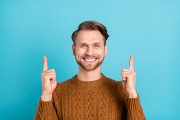 Sticker - Photo of happy attractive young man point fingers up empty space sale solution isolated on blue color background