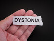© Stepan Popov - A man holding a torn piece of paper with the word Dystonia on it in his hand