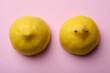 Yellow lemon halves with piercing on pink background, flat lay