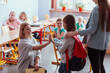 © Photographee.eu - Girl with a red backpack says hello to her friends on her first day of school